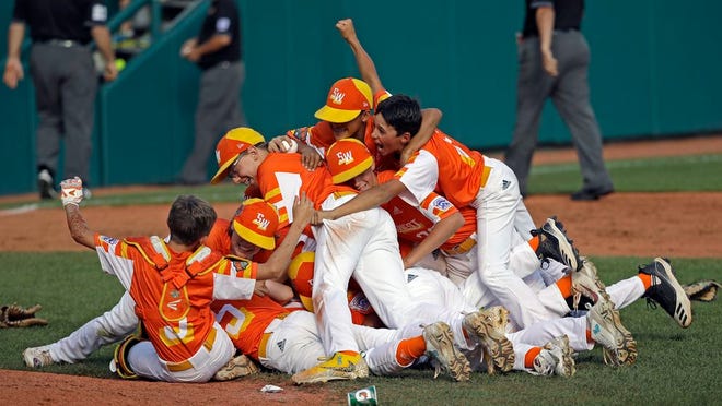 River Ridge, Louisiana's Stan Wiltz embraces Peyton Spadoni (6) on top of the pile as they celebrate the 8-0 win against Curacao in the Little League World Series Championship baseball game in South Williamsport, Pa., on Sunday.