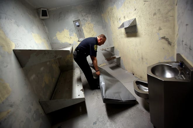 Captain Rodney Fitch places a mat on the floor of a jail cell to make room for more inmates on Thursday. The Cleveland County Detention Center is currently overcrowded due long waits for inmates to be sent to state prisons. [Brittany Randolph/The Star]