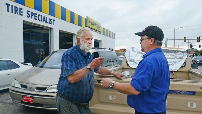 Gary Rogers, left, visits with Sheldon DeArvil, service manager for Kansasland Tire and Service after DeArvil collected a donation from employees to raise money for a new vehicle for Rogers, who was living in his old F-150 pickup truck in the Kansasland parking lot. A local breakfast group at McDonald's also pitched in. [AARON ANDERS/SALINA JOURNAL]