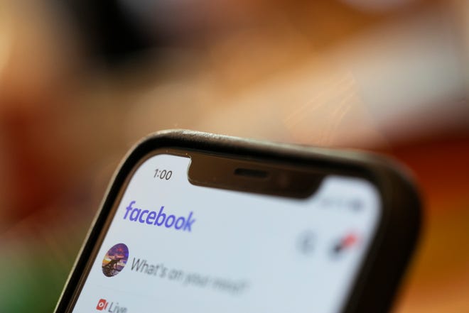 FILE - In this Aug. 11, 2019, file photo an iPhone displays a Facebook page in New Orleans. Social media platforms are facing intense, often contradictory demands from Washington to oversee internet content without infringing on First Amendment rights. (AP Photo/Jenny Kane, File)