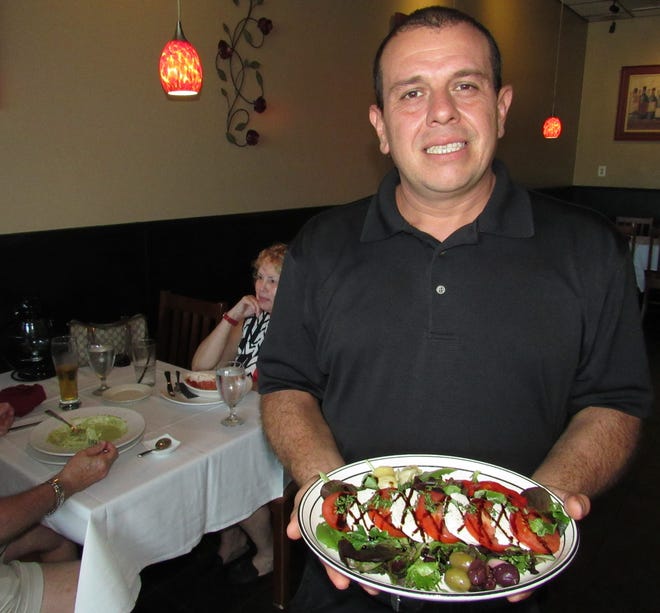 Co-owner Luis Caballeros serves up authentic Italian dishes, like this caprese salad, at Don Luigi's Gourmet Kitchen in Palm Coast. [News-Tribune/Danielle Anderson]