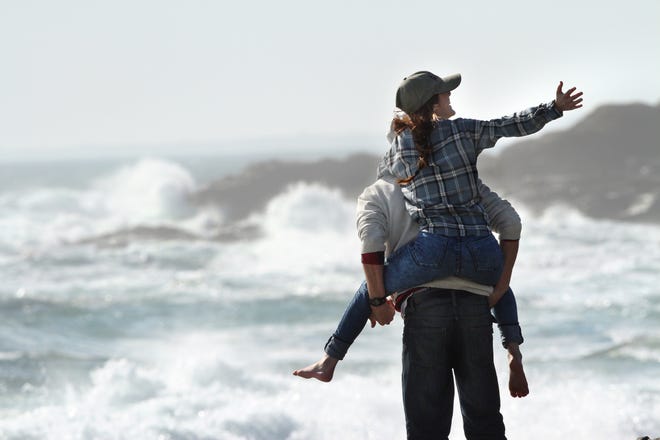 Ashlyn Kistler, of East Greenwich, gets a lift from Will Hopkins, also of East Greenwich, as they watch the waves at Beavertail State Park in Jamestown in 2016. [PROVIDENCE JOURNAL FILE PHOTO]
