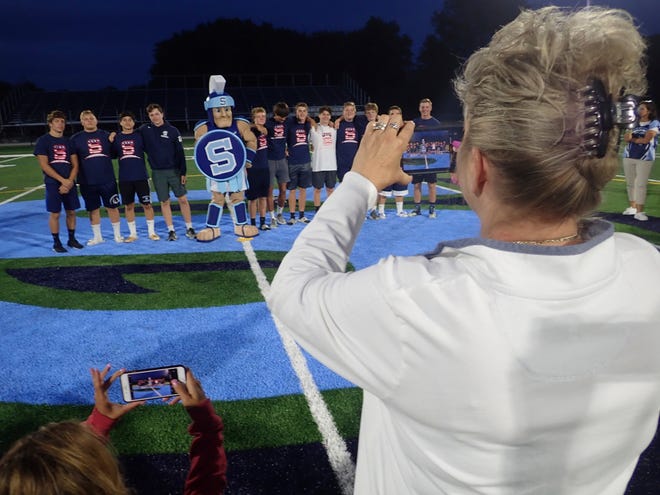 Photo by Bruce A Scruton/New Jersey Herald - Parents grab pictures of the members of the Sparta High School soccer team posing with the school mascot on Monday after ribbon-cutting ceremonies at the school’s new turf field stadium.
