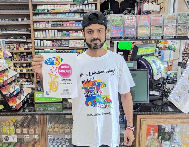 St. Gabriel Mart LLC Manager Zia Ul Islam displays his store’s new celebratory flyer, received after selling an Easy 5 jackpot winning ticket worth $192,435.
