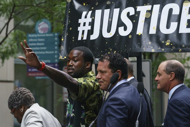 Rapper Meek Mill gestures at the crowd outside the Criminal Justice Center in Center City Philadelphia on Tuesday. Mill pleaded guilty to a 2007 misdemeanor gun charge and won't serve additional time in prison after reaching a plea agreement in a case that's kept him on probation for most of his adult life. [Jessica Griffin/The Philadelphia Inquirer via AP]