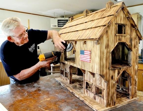 Wayne Dyer nails on the finishing framing to one of the model barns he makes from scratch. (GateHouse Media Ohio / Michael Neilson, Daily-Jeff.com)