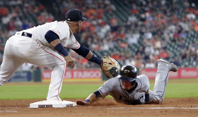 Houston Astros first baseman Yuli Gurriel waits for the throw as Tampa Bay's Matt Duffy dives back to first base during the seventh inning of their game Thursday in Houston. [MICHAEL WYKE/THE ASSOCIATED PRESS]