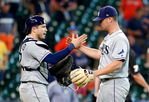 Tampa Bay Rays catcher Travis d'Arnaud, left, and closing pitcher Emilio Pagan, right, celebrate their win over the Houston Astros at the end of a baseball game Thursday, Aug. 29, 2019, in Houston. (AP Photo/Michael Wyke)