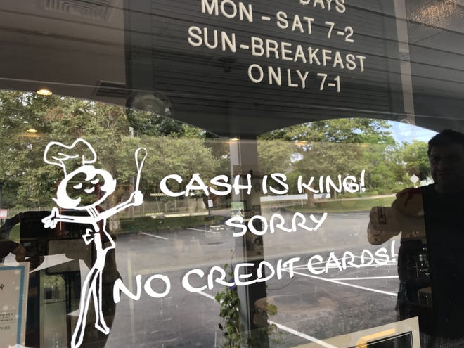 Signage outside Chatham Filling Station reminds patrons to bring cash before entering. [Sarah Klearman photos/Cape Cod Times]