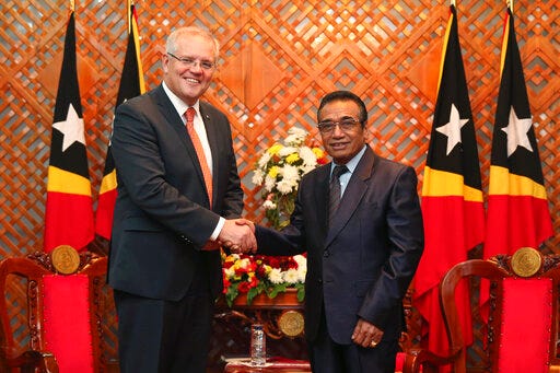 Australian Prime Minister Scott Morrison, left, shakes hands with East Timorese President Francisco Guterres during their meeting in Dili, East Timor, Friday, Aug. 30, 2019. Australia has committed to invest in East Timor's naval infrastructure and provide an undersea internet cable between the countries as China increases its influence in the region. (AP Photo/Kandhi Barnez)