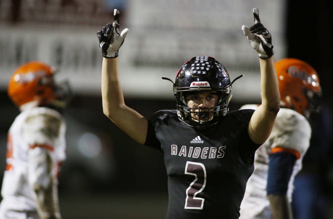 Tyler England signals touchdown after the Raiders scored again as Navarre hosted Escambia in a high school football playoff game at Navarre.[MICHAEL SNYDER/DAILY NEWS]