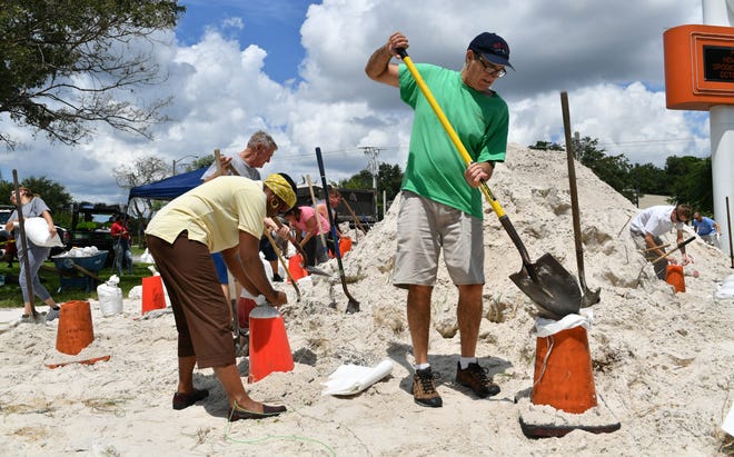 Gail Coom, left, and Martin Selzer, right, fill sandbags Friday afternoon. at Ed Smith Stadium in Sarasota. Coom said she planned to use them to keep water from getting into her house from the lanai. Selzer said his garage floods and he has poor drainage around his house. [Herald-Tribune staff photo / Mike Lang]