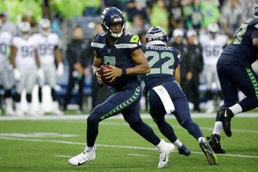 Seattle Seahawks quarterback Geno Smith drops back during the first half of the team's NFL football preseason game against the Oakland Raiders, Thursday, Aug. 29, 2019, in Seattle. (AP Photo/Elaine Thompson)