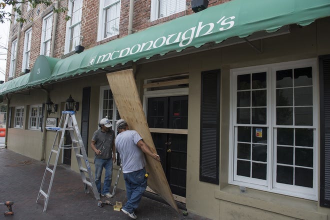 Workers board up McDonough's in preparation for Hurricane Matthew in 2016. Along with securing doors and windows it's important for businesses to have a communication plan in place for both employees and customers ahead of a natural disaster. [Savannah Morning News file photo]
