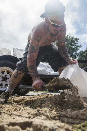 Jason Madden, a Tybee resident, piles sand into a bag at Memorial Park ahead of Hurricane Dorian on Sunday. Adams said after enduring both Matthew and Irma in recent years, he was mostly worried about flooding. [Will Peebles/Savannahnow.com]