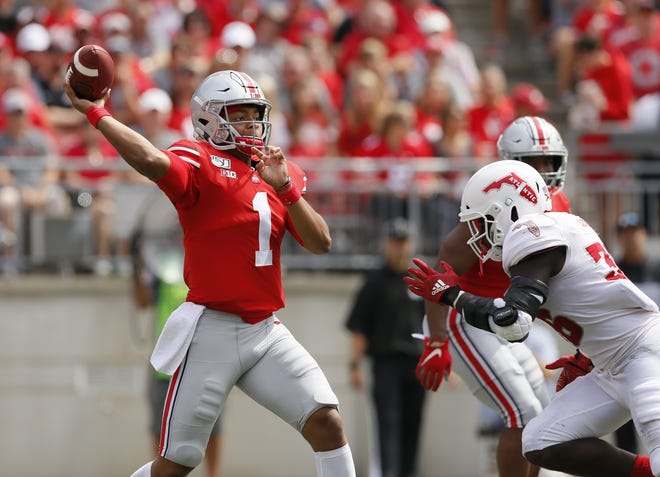 Justin Fields threw four touchdowns and ran for another score in his Ohio State debut. [Adam Cairns/Dispatch]