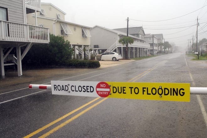 A sign alerts drivers that Canal Drive on Carolina Beach just south of Wilmington, North Carolina, is closed due to flooding caused by heavy rains from Tropical Storm Hermine on Sept. 2, 2016. [GATEHOUSE MEDIA]