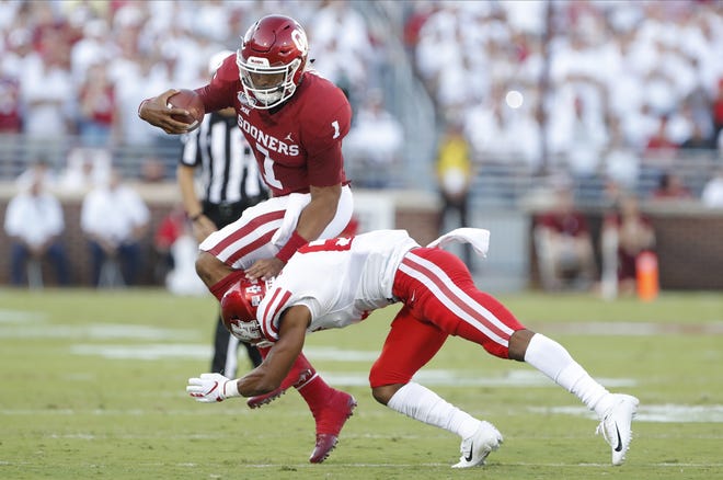 Oklahoma quarterback Jalen Hurts (1) leaps over Houston cornerback Damarion Williams (6) during the first half Sunday in Norman, Oklahoma. [AP Photo/Alonzo Adams]