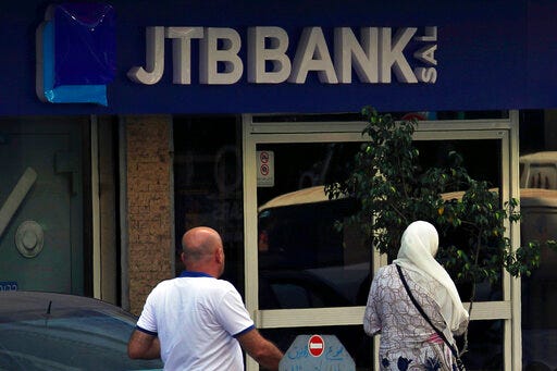 People enter a branch of Jammal Trust Bank in Beirut, Lebanon, Friday, Aug. 30, 2019. The Lebanese bank targeted by the U.S. Department of the Treasury for "knowingly facilitating banking activities" for the militant Hezbollah group has denied the charges, saying it abides by international laws. (AP Photo/Bilal Hussein)