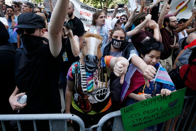 Counterprotesters, including one wearing a horse mask, line the route of the Straight Pride Parade in Boston, Saturday, Aug. 31, 2019. (AP Photo/Michael Dwyer)