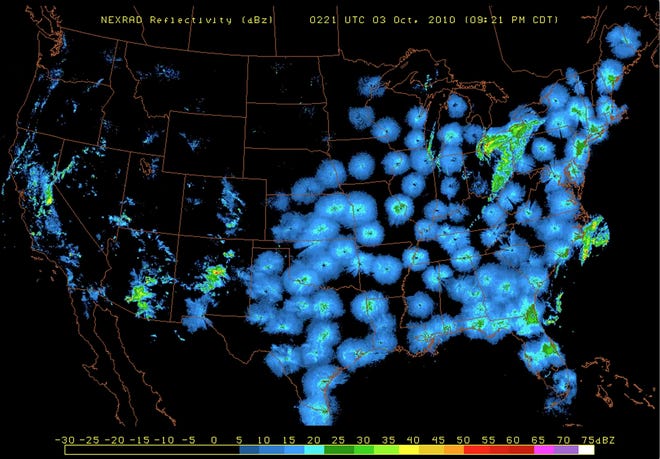 A snapshot of BirdCast's national radar imagery, featuring large numbers of birds taking flight. Circular blue and green features represent bird migration. Precipitation appears as irregular bands. [CONTRIBUTED]