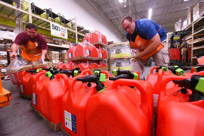 Mark Bratton and Chris Earley put out gas tanks at the Home Depot in Monkey Junction Monday. (Ken Blevins/StarNews)