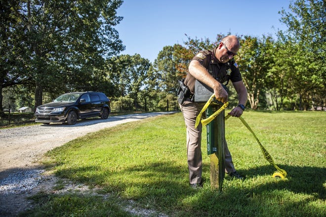 Limestone County Sheriff Sgt. Jonathan Hardiman adds caution tape at the scene of a shooting, Tuesday, Sept. 3 in Elkmont. A 14-year-old boy admitted to killing five members of his family, including his three younger siblings. [Dan Busey/The Decatur Daily]