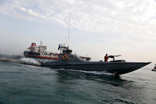 FILE - In this July 21, 2019 file photo, a speedboat of the Iran's Revolutionary Guard moves around a British-flagged oil tanker, the Stena Impero, which was seized by the Guard, in the Iranian port of Bandar Abbas. The U.S. Navy is trying to put together a new coalition of nations to counter what it sees as a renewed maritime threat from Iran. Meanwhile, Iran finds itself backed into a corner and ready for a possible conflict. It stands poised on Friday, Sept. 6, 2019, to further break the terms of its 2015 nuclear deal with world powers. (Hasan Shirvani/Mizan News Agency via AP, File)