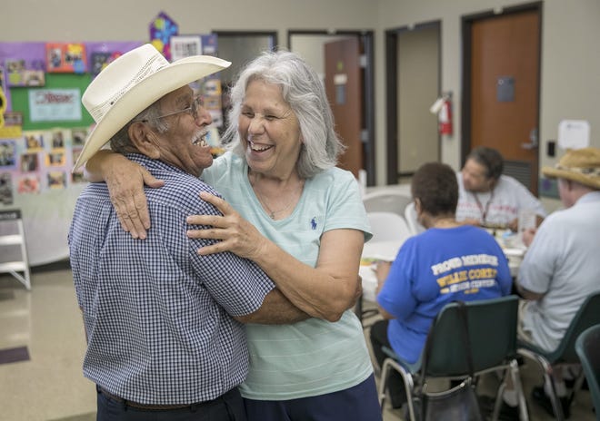 Volunteer Elsa Solis, right, a retired state caseworker, greets Robert Maldonado at the Willie M. Cortez Senior Center in San Antonio on Thursday. Solis has delayed needed repairs to her house and car because of a tight budget. [JAY JANNER/AMERICAN-STATESMAN]