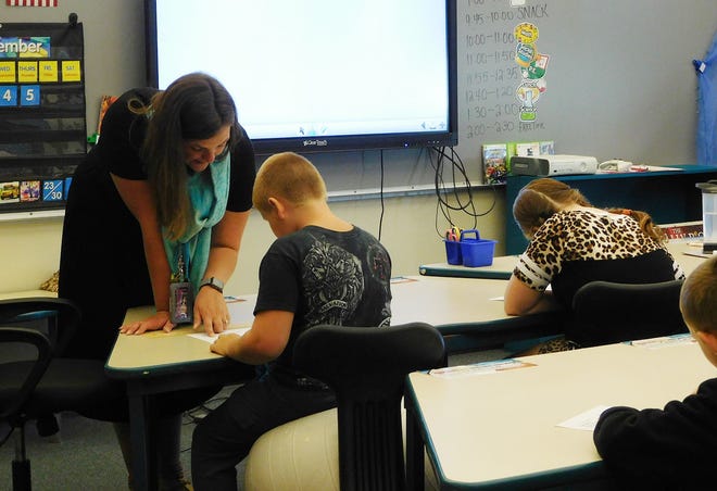 Children returned to school throughout the region Thursday, including in the Little Falls City School District. Pictured is Benton Hall Academy teacher Samantha Gallt working with a student on a math sheet during the first day of school. [STEPHANIE SORRELL-WHITE/TIMES TELEGRAM]