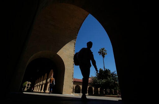 FILE - In this April 9, 2019, file photo, pedestrians walk on the campus at Stanford University in Stanford, Calif. College students who earned money this summer can make the most of it by including a few longer-term financial goals in their budgeting. (AP Photo/Jeff Chiu, File)