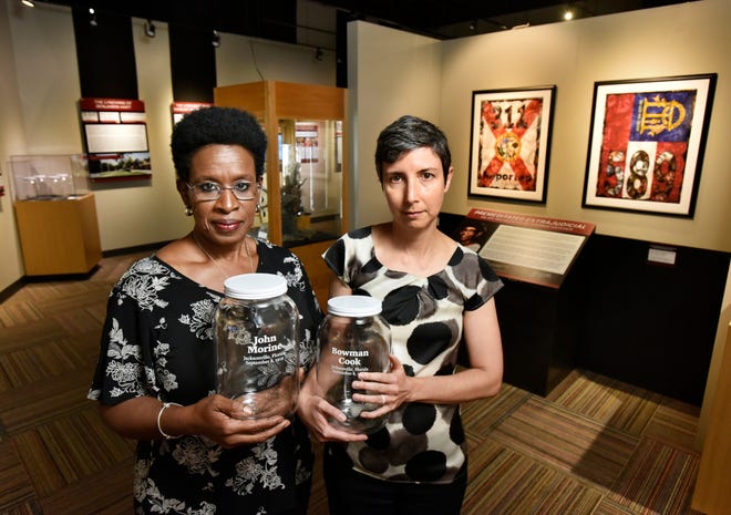 Lynn Sherman (left) and Melanie Patz, co-chairs of Jacksonville's Community Remembrance Project, hold jars that memorialize the lynchings of John Morine and Bowman Cook on Sept. 8, 1919. The jars have been part of a display on lynchings at the Museum of Science and History, and will be returned there after a ceremony Sunday where they'll be filled with soil from the site of the killings. [Will Dickey/Florida Times-Union]