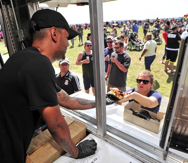 Michael Parker serves another customer in the Gotta Q food truck during the 2018 New Bedford Food Truck & Craft Beer Festival held at Fort Taber Park. [DAVID W. OLIVEIRA/STANDARD-TIMES SPECIAL/SCMG]