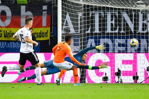 Netherlands' Donyell Malen, center, scores his side's third goal past Germany goalkeeper Manuel Neuer during the Euro 2020 group C qualifying soccer match between Germany and the Netherlands at the Volksparkstadion in Hamburg, Germany, Friday, Sept. 6, 2019. (AP Photo/Martin Meissner)