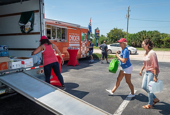 Christina Upchurch, Cathy Upchurch-Smith and Allie Smith load donated relief supplies for the Bahamas in a truck in the parking lot of St. Augustine Court Reporters on North Ponce De Leon Boulevard in St. Augustine on Friday. Fried Chicken Kitchen food truck, which is also parked in the parking lot, is collecting relief supplies 11 a.m. to 5 p.m. Saturday and Sunday there which will then be flown to the Bahamas by local pilots. Anyone making a donation will get a free chicken meal from the food truck. [PETER WILLOTT/THE RECORD]