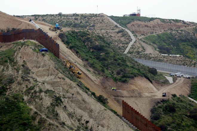 Construction crews replace a section of the primary wall separating San Diego, above right, and Tijuana, Mexico, below left, seen from Tijuana, Mexico. Defense Secretary Mark Esper has approved the use of $3.6 billion in funding from military construction projects to build 175 miles of President Donald Trump’s wall along the Mexican border.[Gregory Bull/The Associated Press]