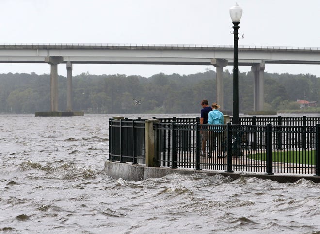 Onlookers watched storm surge and water levels rise near the waterfront walkways along the Neuse River at East Front Street and Union Point Park in New Bern Thursday. [Gray Whitley / Sun Journal Staff]