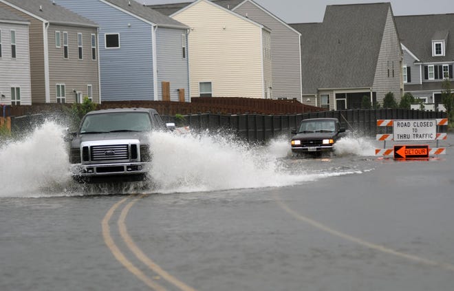 Cars drive along a flooded Torchwood Drive on Thursday in Wilmington. Hurricane Dorian's effects started strong, but didn't bring more flooding to an already-soaked part of the county. [MATT BORN/STARNEWS]