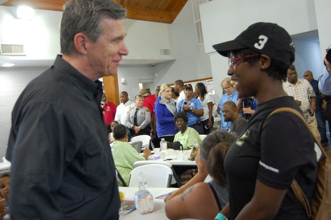 N.C. Gov. Roy Cooper met with families, evacuees and community advocates Friday at Warner Temple AME Zion Church on Nixon Street. Northside Bridge Builders was offering meals supplies out of the church. [CAMMIE BELLAMY/STARNEWS]