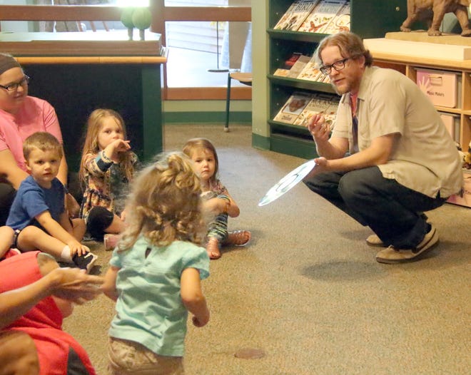 Rusty Ray Reed give youngsters a close up of vinyl record during Dickson Mounds Museum’s Tot Time program Thursday morning. [Hannah Schrodt/Daily Ledger]
