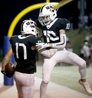 Westmoore's Colby Phillips (17) and Andrew Metcalf (10) celebrate a Phillips touchdown during the Jaguars' 44-35 win Friday. [Sarah Phipps/The Oklahoman]