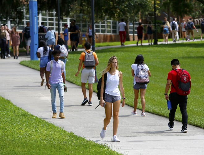 Students walk through the University of Florida campus on the first day of classes at the university on Aug. 20. Records and archived web pages show UF officials billed students hundreds of dollars for "Preview," a costly and mandatory version of the university's new-student orientation. Since at least 2007, the university charged students for orientation at a rate three to five times higher than state law allows. [Brad McClenny/Staff photographer]