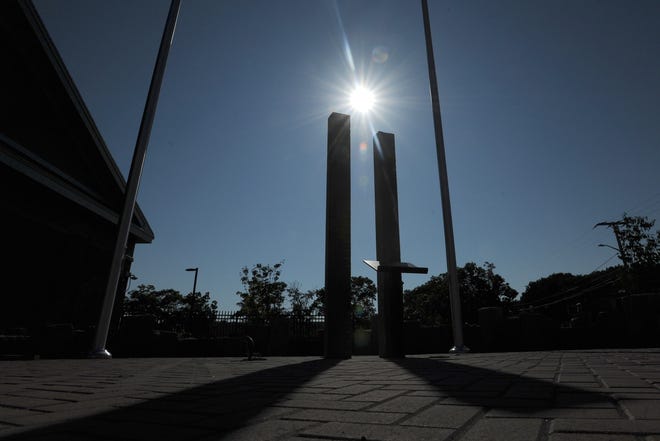 The afternoon sun shines over granite posts at the nearly complete Sept. 11 memorial at the new Hyannis fire station. The posts represent the two World Trade Center towers. [Merrily Cassidy/Cape Cod Times]