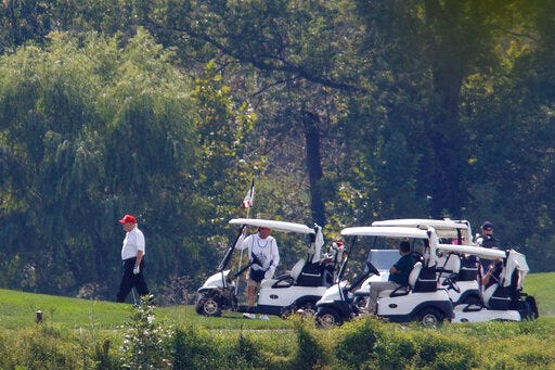 President Donald Trump, left, participates in a round of golf at the Trump National Golf Course in Sterling, Va., Sunday, Sept. 8, 2019. (AP Photo/ Tom Brenner)