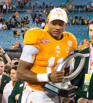 Tennessee Volunteers quarterback Joshua Dobbs (11) receives the most valuable player trophy at the 2015 TaxSlayer Bowl in Jacksonville. Dobbs joined the Jaguars Monday in a trade from the Steelers. [Gary Lloyd McCullough/For the Times-Union/File]