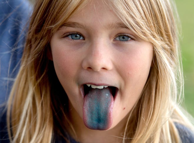 Celia Williams, 10, a fifth-grader at Washington Gifted School, shows off her blue tongue after eating a blue sno-cone Monday, Sept. 9, 2019 at the school. Her class was rewarded with the treat after winning a contest in which they made videos showing what makes Peoria great. [MATT DAYHOFF/JOURNAL STAR]