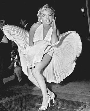 Marilyn Monroe poses over the updraft of New York subway grating while in character for the filming of "The Seven Year Itch" in Manhattan on Sept. 9, 1954. The former Norma Jean Baker modeled and starred in 28 movies grossing $200 million. [Matty Zimmerman/The Associated Press]