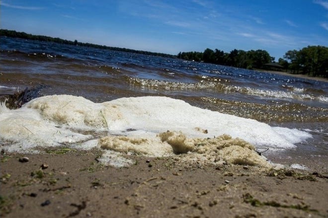 In this June 6, 2018 photo, PFAS foam washes up on the shoreline of Van Etten Lake in Oscoda Township, Mich. near Wurtsmith Air Force Base. The White House recently announced oppositions to PFAS provisions in the Senate's most recent defense spending bill. (Jake May/The Flint Journal via The Associated Press)