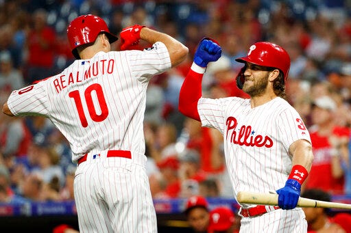 Philadelphia Phillies' J.T. Realmuto, left, and Bryce Harper celebrate after a home run by Realmuto during the first inning of a baseball game against the Atlanta Braves, Tuesday, Sept. 10, 2019, in Philadelphia. (AP Photo/Matt Slocum)