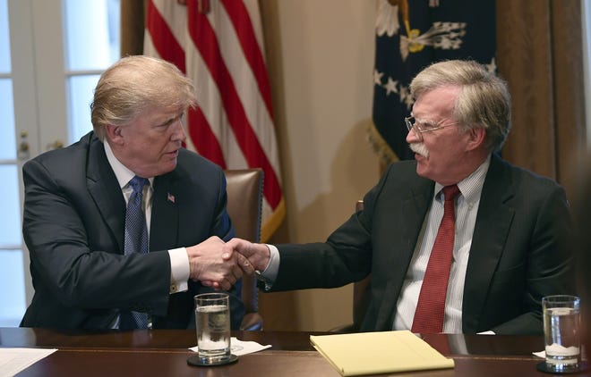 In this April 9, 2018, file photo, President Donald Trump, left, shakes hands with national security adviser John Bolton in the Cabinet Room of the White House in Washington at the start of a meeting with military leaders. Trump has fired Bolton. [AP Photo/Susan Walsh]